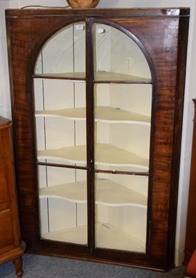 Lot 1264 - A large 19th century glazed mahogany hanging corner cupboard with painted shelved interior...