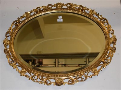 Lot 1265 - An oval bevel edged wall mirror in gilt wood Florentine frame, 83cm by 65cm