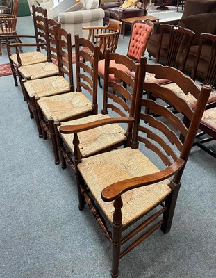 Lot 1324 - A set of six oak ladder back rush seated dining chairs including two carvers (6)