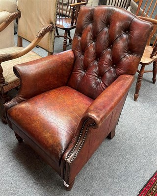 Lot 1380 - An early 20th century brown leather button-backed and studded armchair