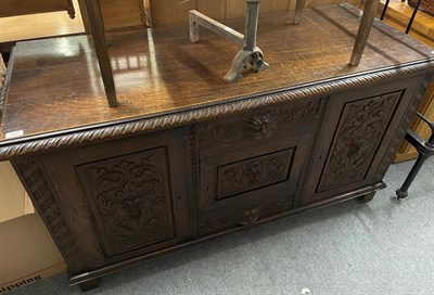 Lot 1422 - A 19th century carved oak cupboard, the carved panels decorated with masks, 152cm by 61cm by 84cm