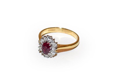 Lot 167 - An 18 carat gold ruby and diamond cluster ring, the oval cut ruby within a border of round...
