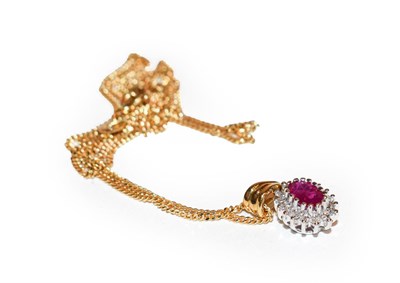 Lot 169 - An 18 carat gold ruby and diamond cluster pendant on chain, the oval cut ruby within a border...