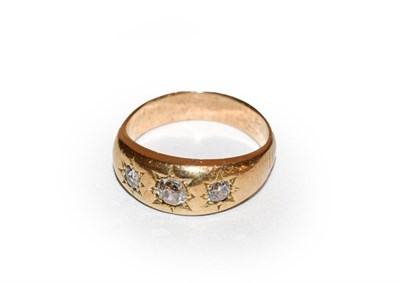 Lot 175 - A diamond three stone ring, the old cut diamonds in yellow star settings, to a plain polished...