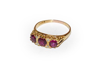 Lot 212 - An 18 carat gold ruby and diamond ring, three graduated oval cut rubies with diamond accents,...
