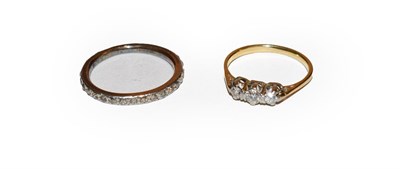 Lot 215 - A diamond three stone ring, finger size M and a diamond eternity ring, finger size P