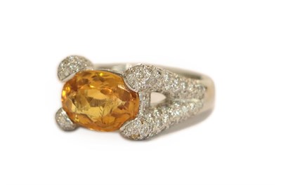 Lot 223 - A citrine and diamond dress ring, the oval cut citrine in a claw setting set throughout with...