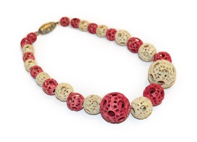 Lot 229 - A red and white ivory bead necklace, late Qing Dynasty, with a Japanese clasp, length 45cm