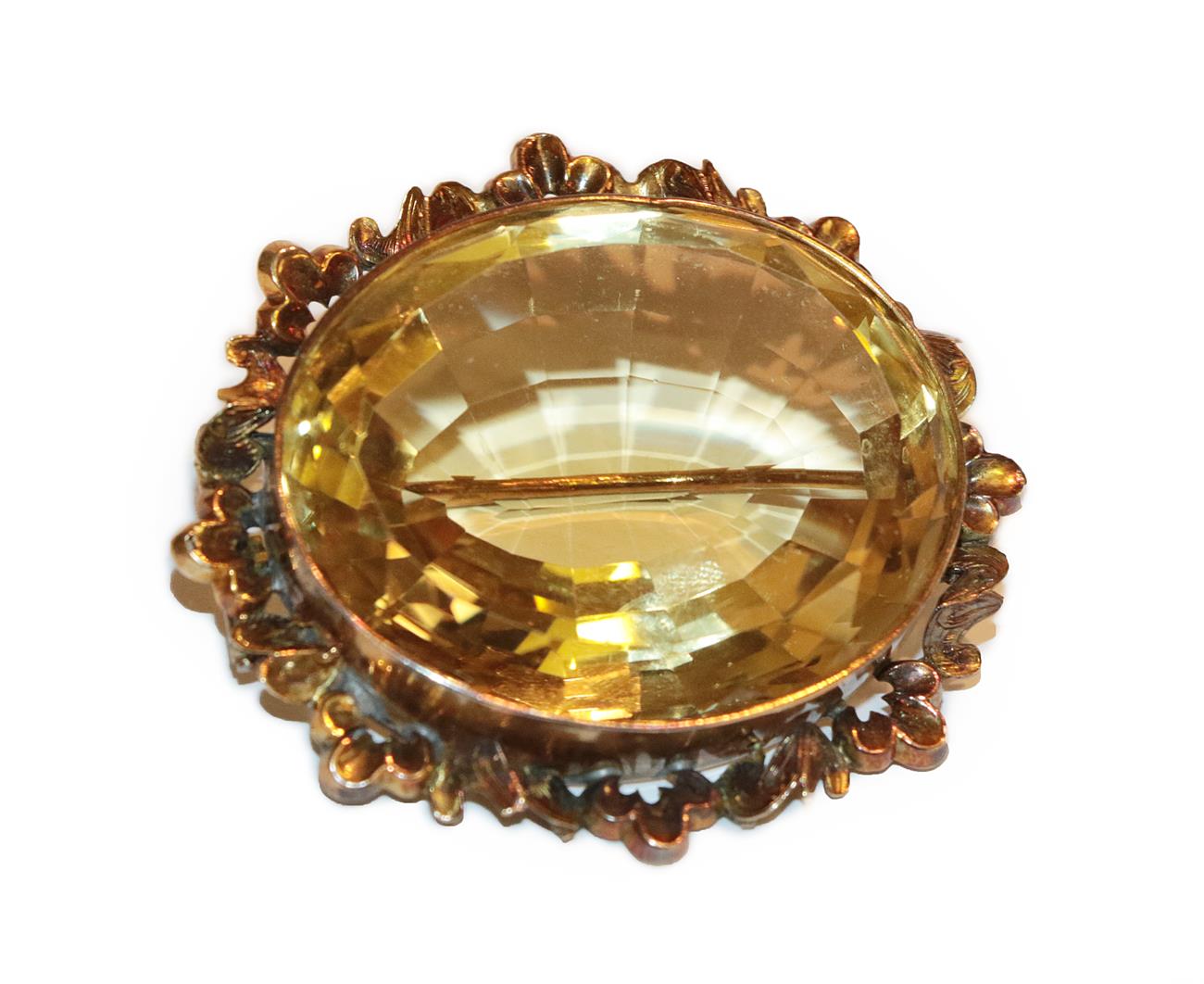 Lot 243 - A late Victorian citrine brooch, the oval cut citrine in a yellow rubbed over setting, within a...