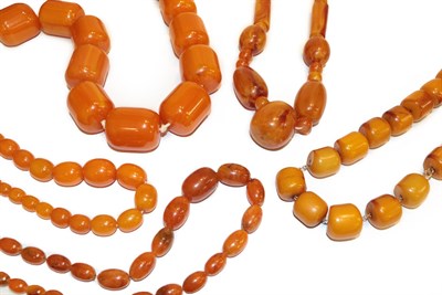Lot 245 - An amber bead necklace, length 68cm and four amber type necklaces, various designs and lengths