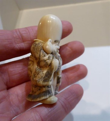 Lot 251 - Two Japanese netsukes, one a sage of a child, a netsuke of a man with a gourd and a further...
