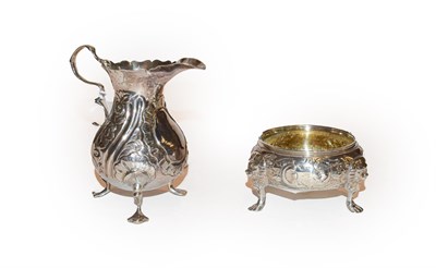 Lot 285 - A George II Irish silver salt-cellar and a George III silver cream jug, the first with rubbed...