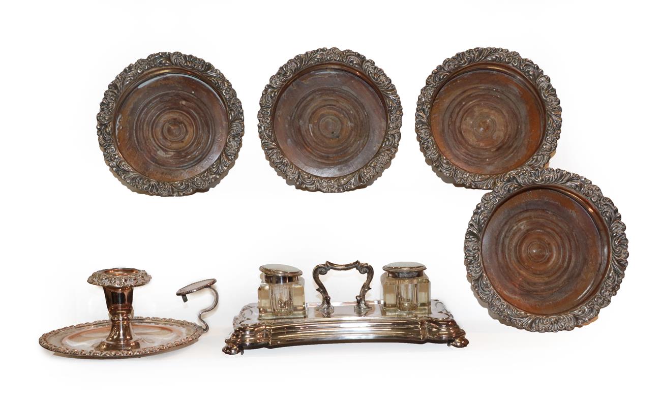 Lot 374 - A set of four silver plated wine coasters with turned wooden bases, a plated chamber stick and...