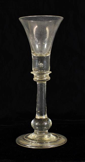 Lot 7 - A Cordial Glass, circa 1720, the trumpet bowl with air tear to solid base, on annular knops,...