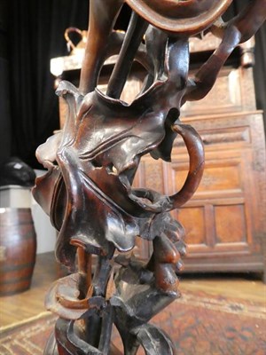 Lot 91 - A Chinese Hardwood Carving, late Qing Dynasty, carved and pierced as lily leaves, tendrils and seed