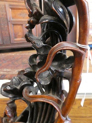 Lot 91 - A Chinese Hardwood Carving, late Qing Dynasty, carved and pierced as lily leaves, tendrils and seed