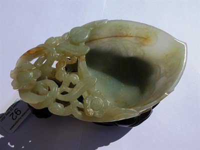 Lot 92 - A Chinese Jade Libation Cup, in the form of a peach with pierced foliate scroll handle, 12cm...