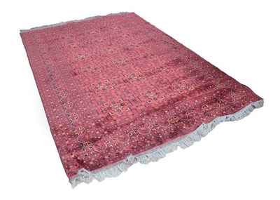 Lot 335 - Afghan Carpet, early 21st century The deep brick red compartmentalised field enclosed by...