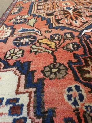 Lot 355 - Malayir Runner West Iran, circa 1930 The faded rose pink field of flowers flanking medallions...