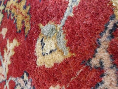 Lot 379 - Large Indian Carpet, modern The brick red field with an allover design of flowing vines and...
