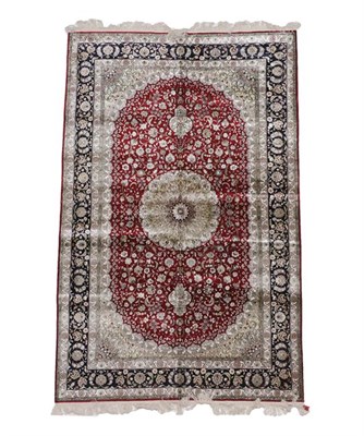 Lot 386 - Modern Chinese Silk Rug The claret field of scrolling vines around a flowerhead medallion framed by