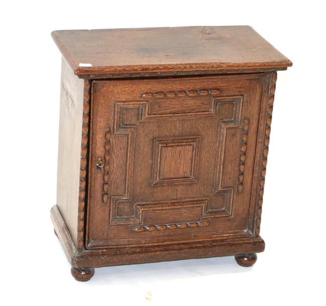 Lot 428 - ~ A 17th Century Oak Spice Cabinet, the moulded top above a geometric moulded drawer enclosing...