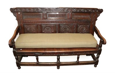 Lot 491 - A Joined Oak Settle, incorporating 18th century elements, the carved top rail above nulled...