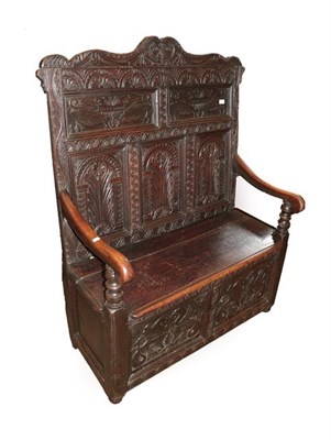 Lot 492 - A Victorian Carved Oak Box Settle, late 19th century, the carved and fielded back support above...