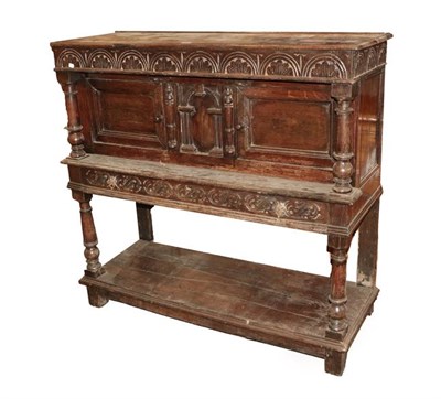 Lot 494 - A 17th Century Joined Oak Standing Livery Cupboard, the boarded top above a lunette carved...