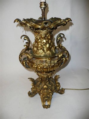 Lot 1300 - A Gilt Metal Lamp Base in Renaissance Style, the waisted neck with tritons over a melon fluted...