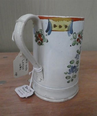 Lot 6 - An early 19th century Leeds pearlware cylindrical tankard with reeded strap handle, painted in...