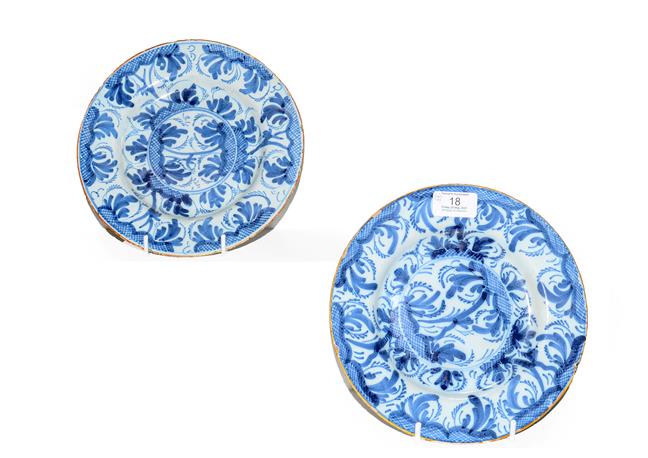 Lot 18 - A pair of 18th century Delft blue and white plates painted with stylized trees under orange...