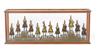 Lot 1335 - A Set of Twelve Painted Wood Figures of Military Horsemen, in yellow breastplates and helms...