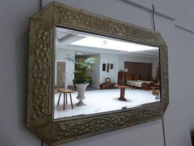 Lot 1034 - A Scottish Arts & Crafts Rectangular Patinated Metal Mirror, bevelled plate within repoussé...