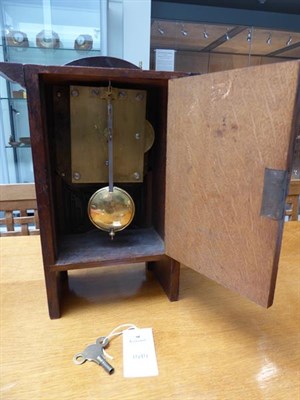 Lot 1040 - An Arts & Crafts Oak and Copper Mantel Clock, domed top, oak rivets, the hammered dial with...