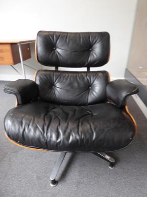 Lot 1185 - Charles and Ray Eames: A Brazilian Rosewood Lounge Chair and Ottoman, 1970s, the black leather...