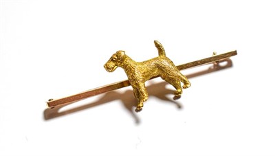 Lot 100 - A bar brooch surmounted with a terrier, stamped '15CT', length 5.1cm