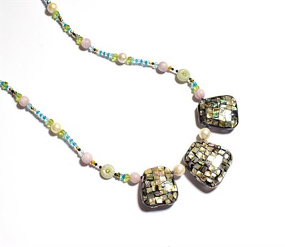 Lot 109 - A multi-gemstone bead necklace, three graduated abalone mosaic panels centrally spaced by...