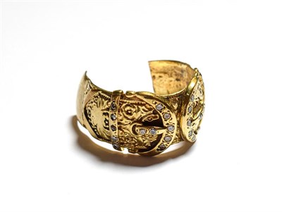 Lot 115 - A 9 carat gold paste set buckle ring, band cut