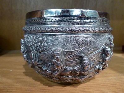 Lot 138 - A Burmese silver bowl, circular, the sides embossed with figures in high relief in landscapes,...