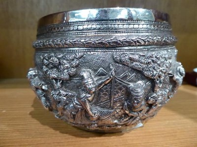 Lot 138 - A Burmese silver bowl, circular, the sides embossed with figures in high relief in landscapes,...