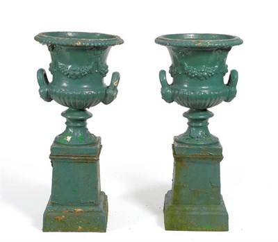 Lot 1390 - A Pair of Green Painted Cast Iron Campana Urns, 19th century, with everted gadrooned rims hung with