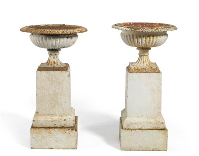 Lot 1391 - A Pair of White Painted Cast Iron Fluted Urns, with egg and dart everted rims, circular fluted...