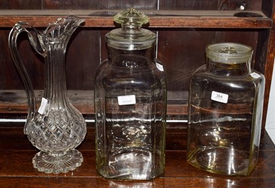 Lot 364 - A large cut glass jug together with two glass storage jars (3)