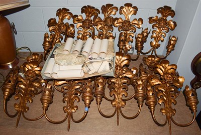 Lot 413 - A set of thirteen gilt metal foliate formed twin branch wall mounting lights with cylindrical glass