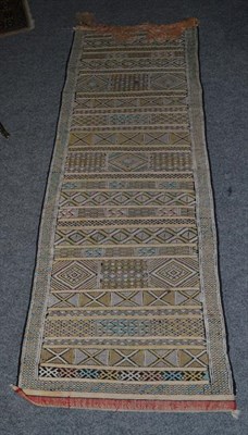 Lot 1112 - A Moroccan Berber flatweave runner, the field with narrow and broad bands of geometric motifs,...