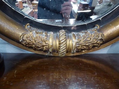 Lot 1119 - A Regency convex circular mirror in gilt frame with ebonised slip, 57cm dia.