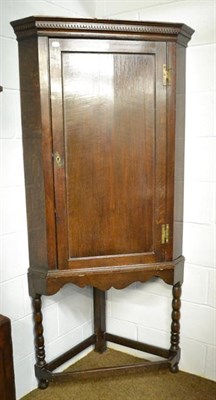 Lot 1130 - A George III panelled oak corner cupboard on stand, 90cm by 55cm by 189cm