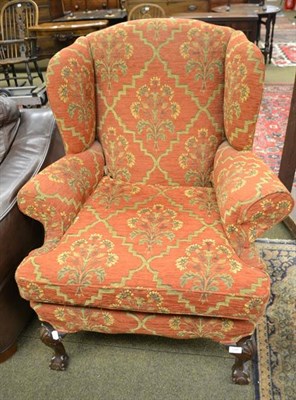 Lot 1186 - A wing back armchair on ball and claw feet