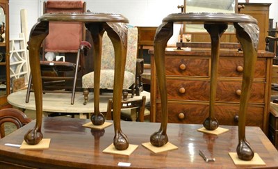 Lot 1208 - A pair of early 20th century carved mahogany plant stands, raised on carved cabriole supports...